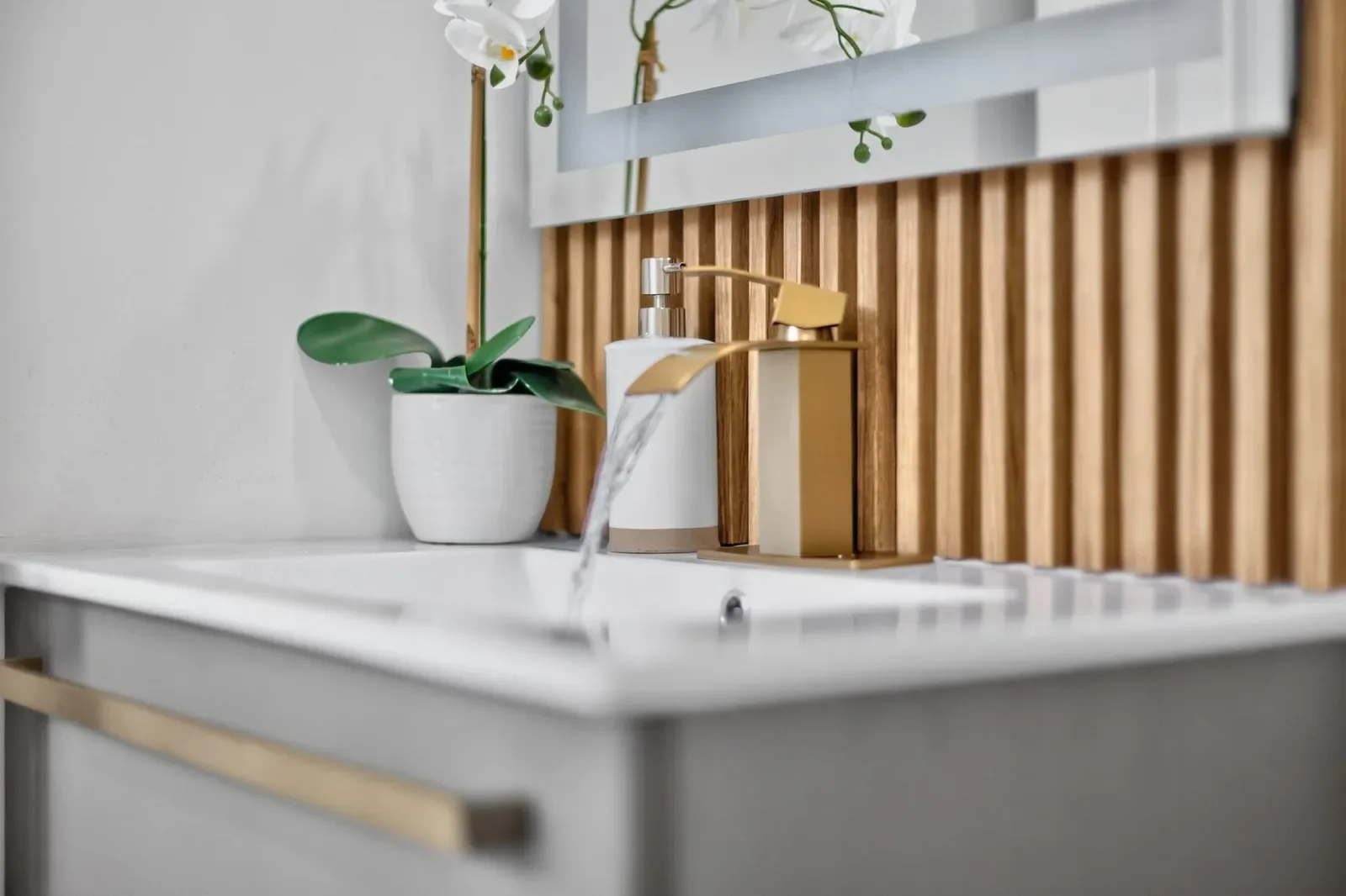 Bathroom vanity detail with brass waterfall faucet in North Florida. Real estate photography by Megapixeler