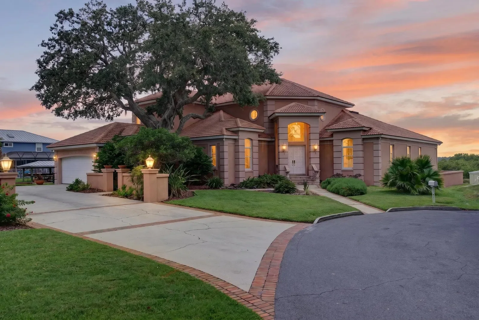 Coastal Mediterranean home at sunset with warm interior lights in St. Augustine, FL. Twilight photography by Megapixeler