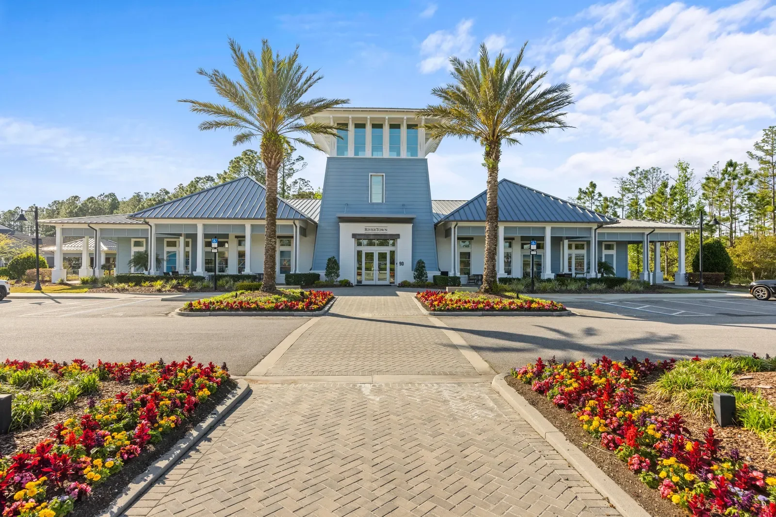 Community clubhouse entrance with palms and flower beds in North Florida. Community amenity photography by Megapixeler