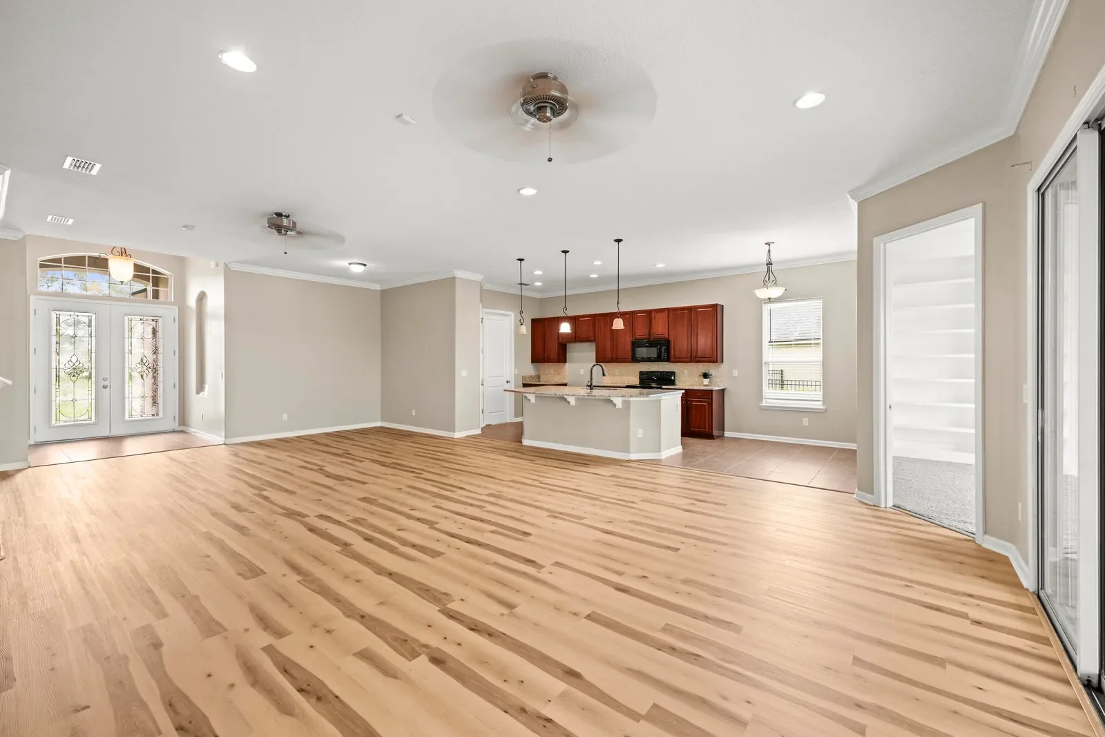 Empty open living area and kitchen before virtual staging in North Florida. Real estate photography by Megapixeler