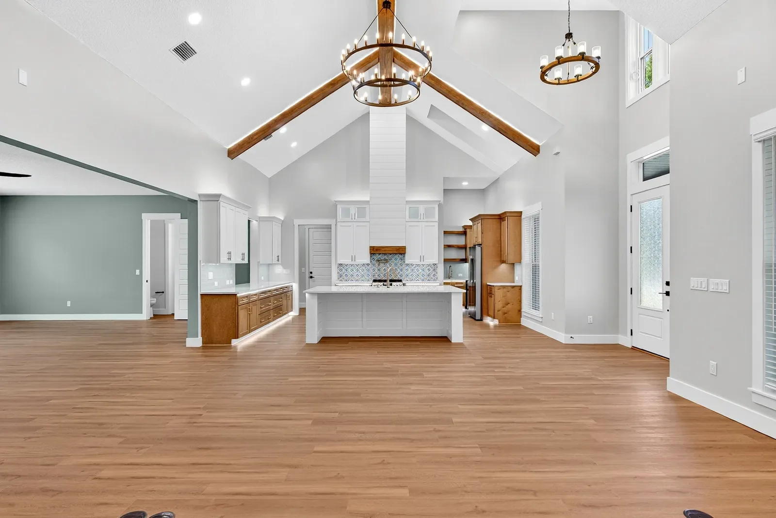 Empty vaulted great room and kitchen before virtual staging in North Florida. Real estate photography by Megapixeler