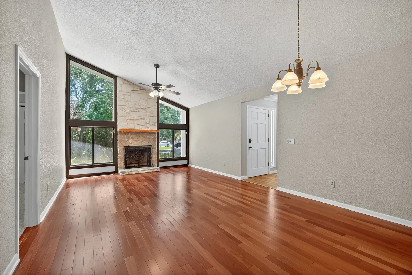 Empty vaulted living room with stone fireplace before virtual staging in North Florida. Real estate photography by Megapixeler