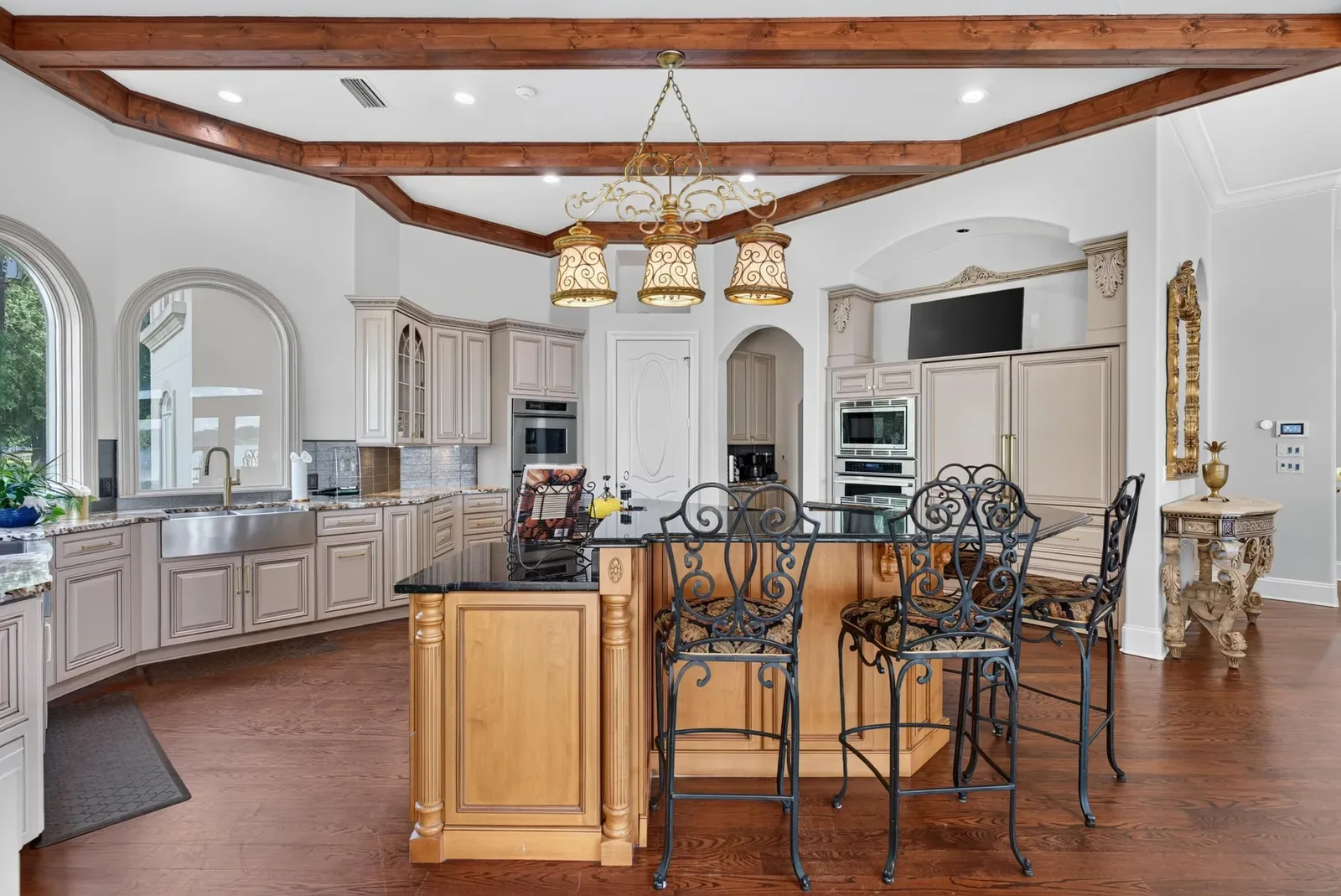 Estate kitchen with coffered ceiling and island seating in Jacksonville, FL. Real estate photography by Megapixeler