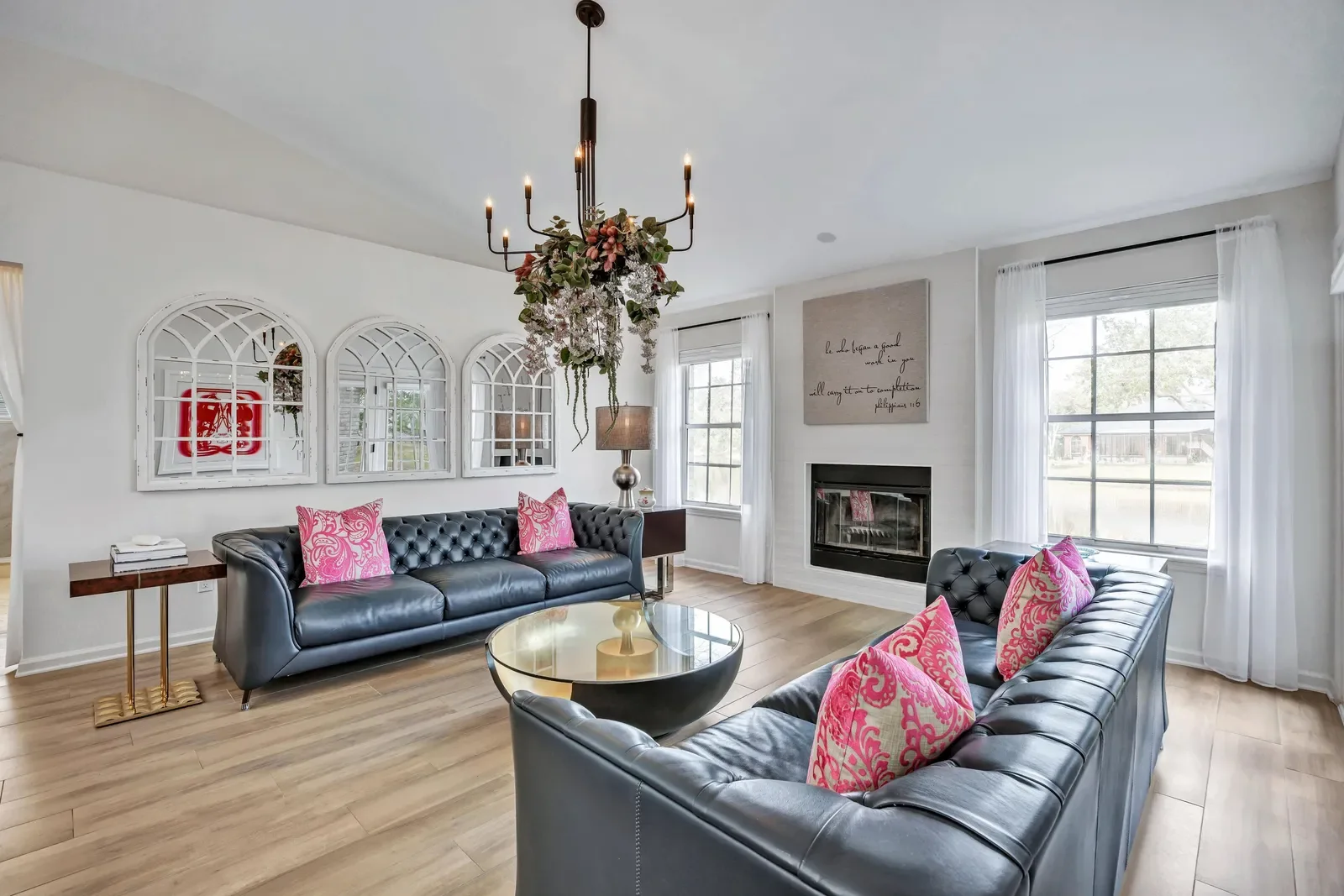Family room with chandelier, fireplace and leather sofas in Orange Park, FL. Real estate photography by Megapixeler