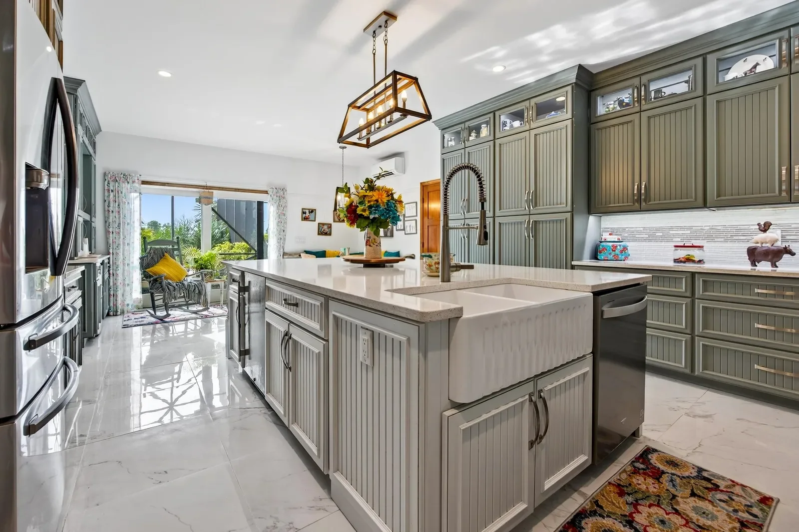 Kitchen with sage cabinets, marble island and lantern pendants in Pomona Park, FL. Real estate photography by Megapixeler