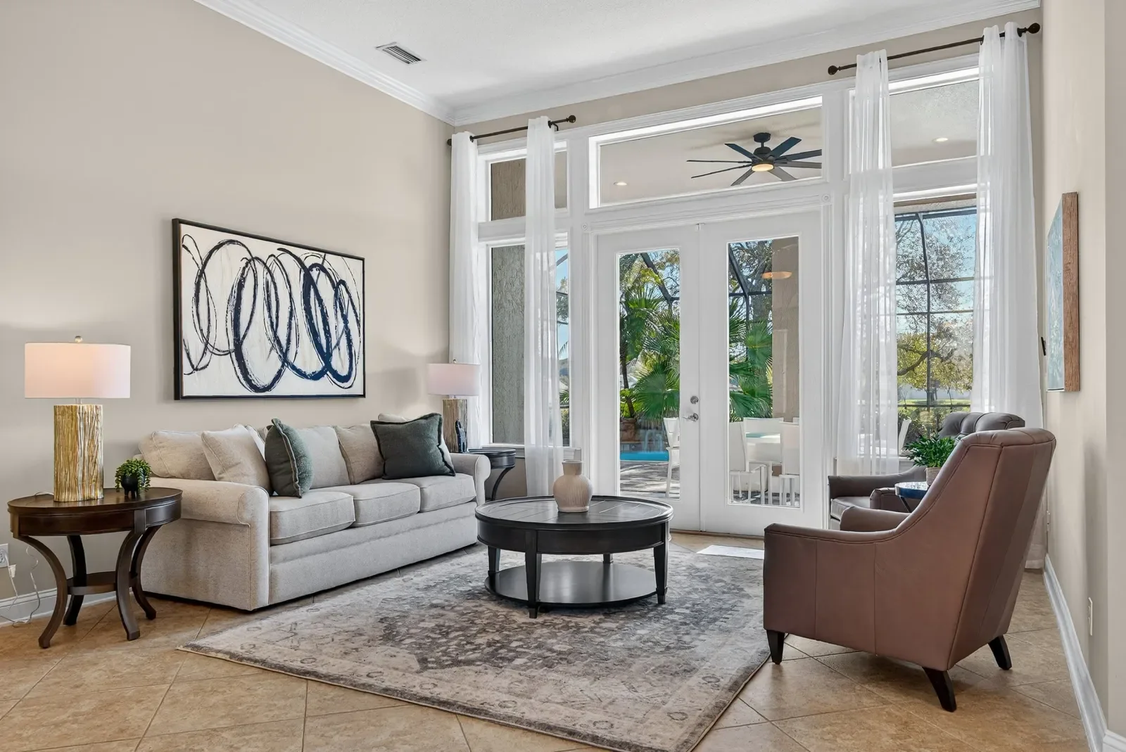 Living room with French doors to the pool and abstract art in St. Johns, FL. Real estate photography by Megapixeler