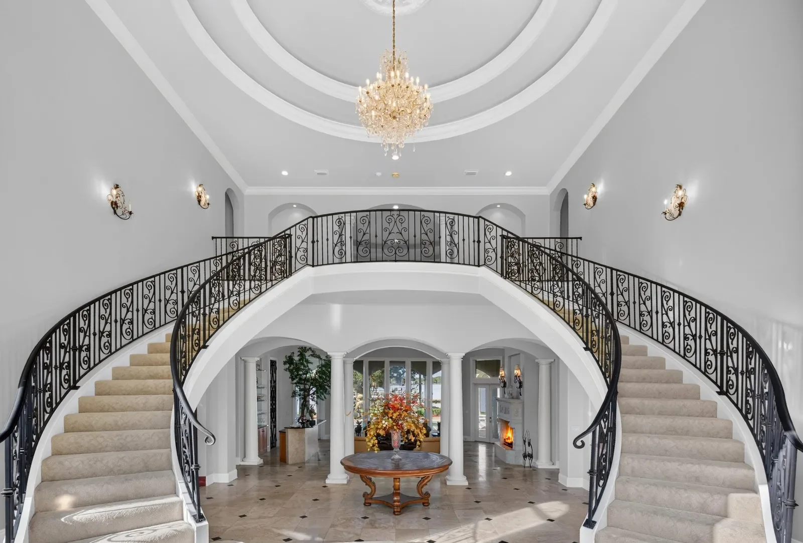 Marble foyer with double curved staircase seen from above in Jacksonville, FL. Drone photography by Megapixeler