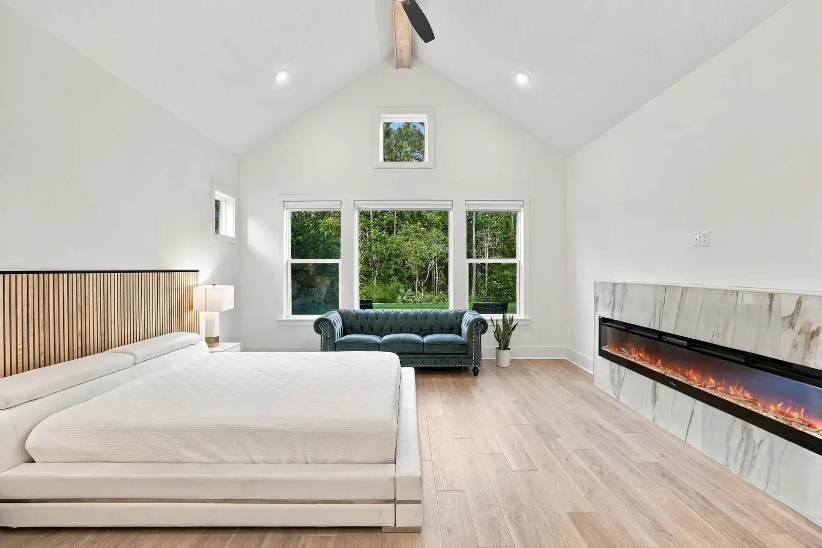 Modern primary suite with vaulted ceiling and linear fireplace in Ponte Vedra Beach, FL. Real estate photography by Megapixeler