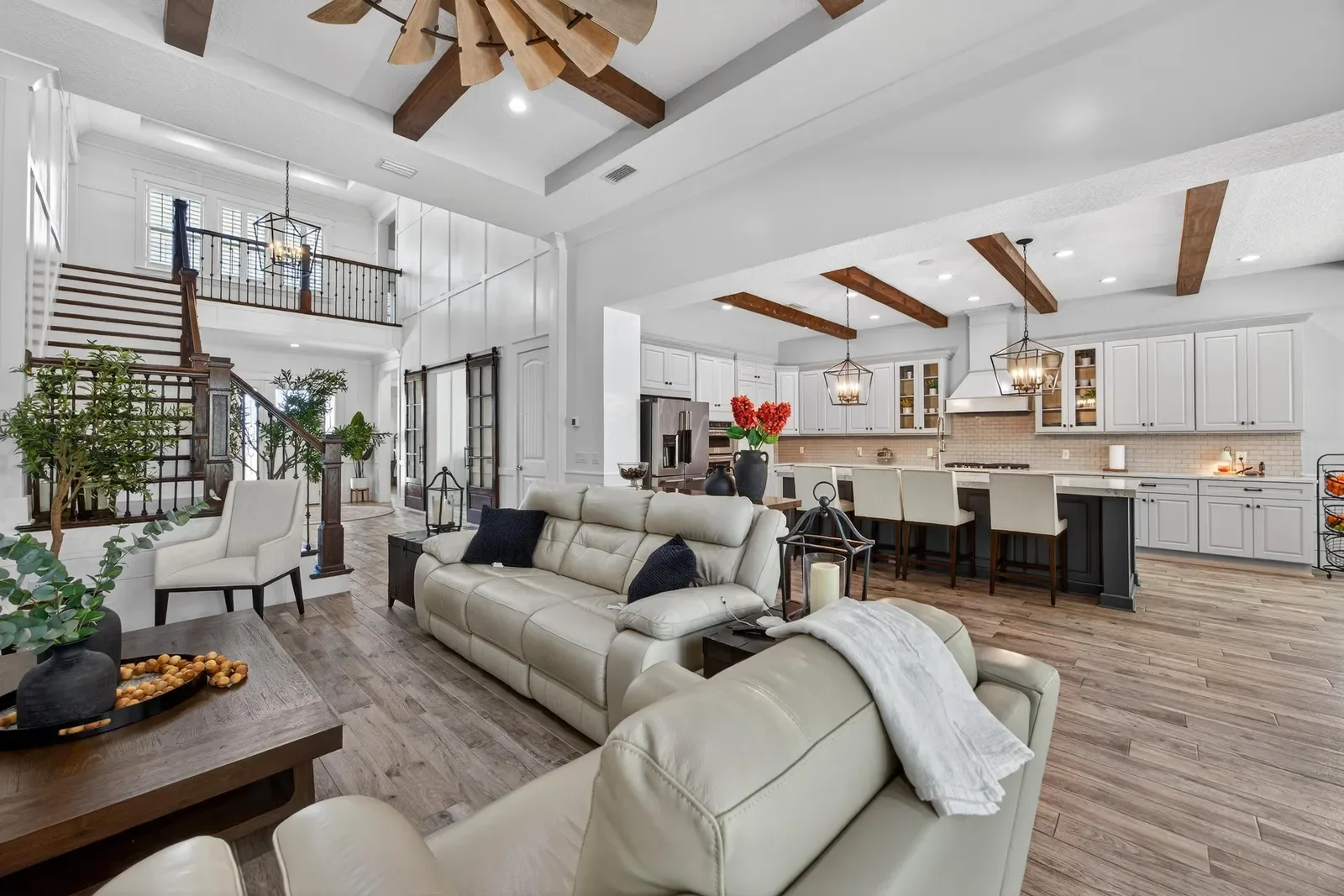 Open great room and kitchen with floating staircase in St. Johns, FL. Real estate photography by Megapixeler