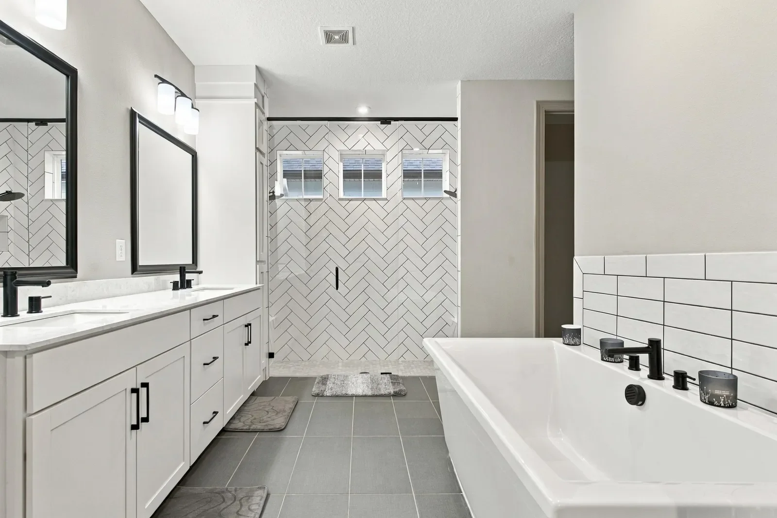 Primary bath with soaking tub and herringbone shower in St. Johns, FL. Real estate photography by Megapixeler