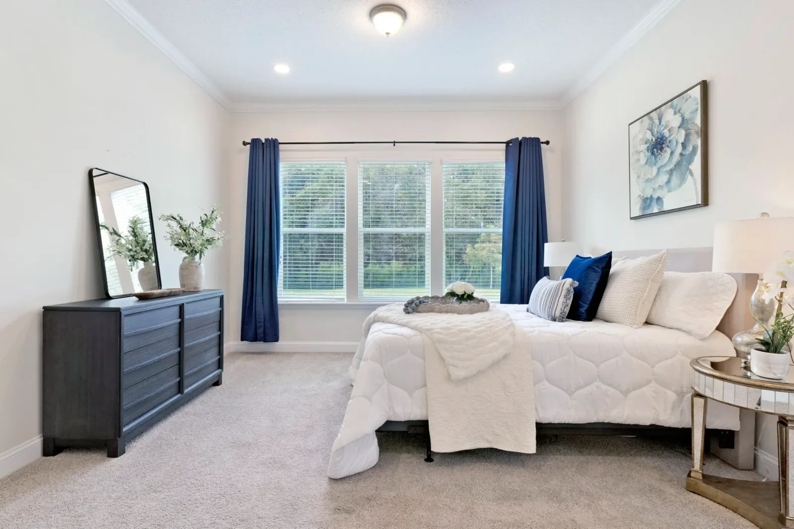 Primary bedroom with navy drapes and wooded views in North Florida. Real estate photography by Megapixeler