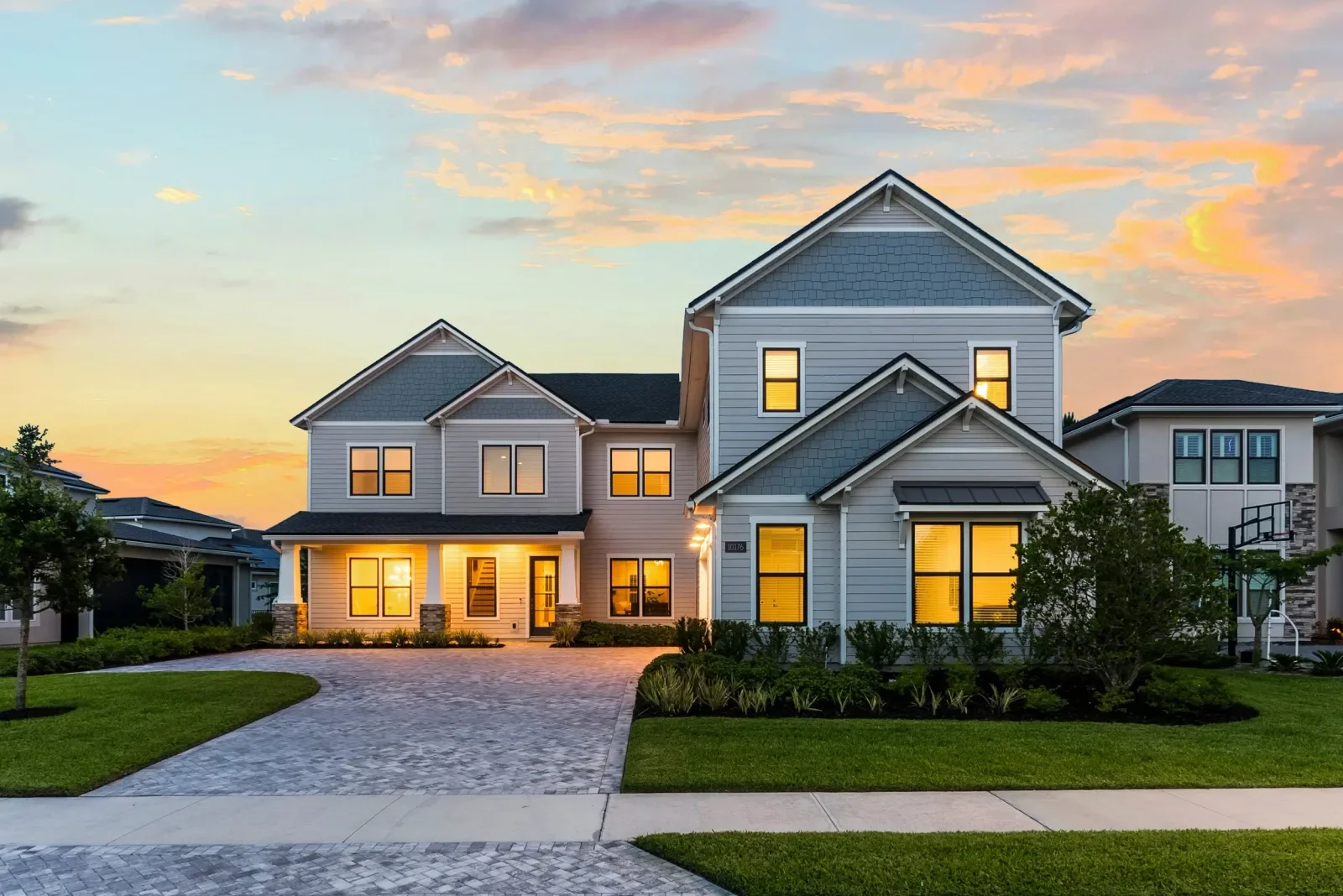 Twilight photo of a two-story coastal home with glowing windows in North Florida. Twilight photography by Megapixeler
