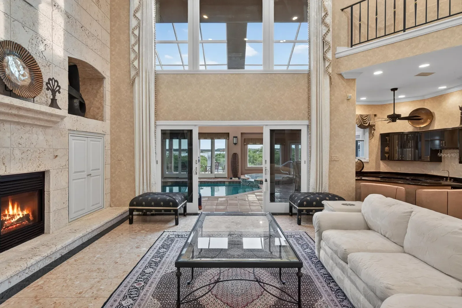 Two-story living room with fireplace and gallery windows in St. Augustine, FL. Real estate photography by Megapixeler
