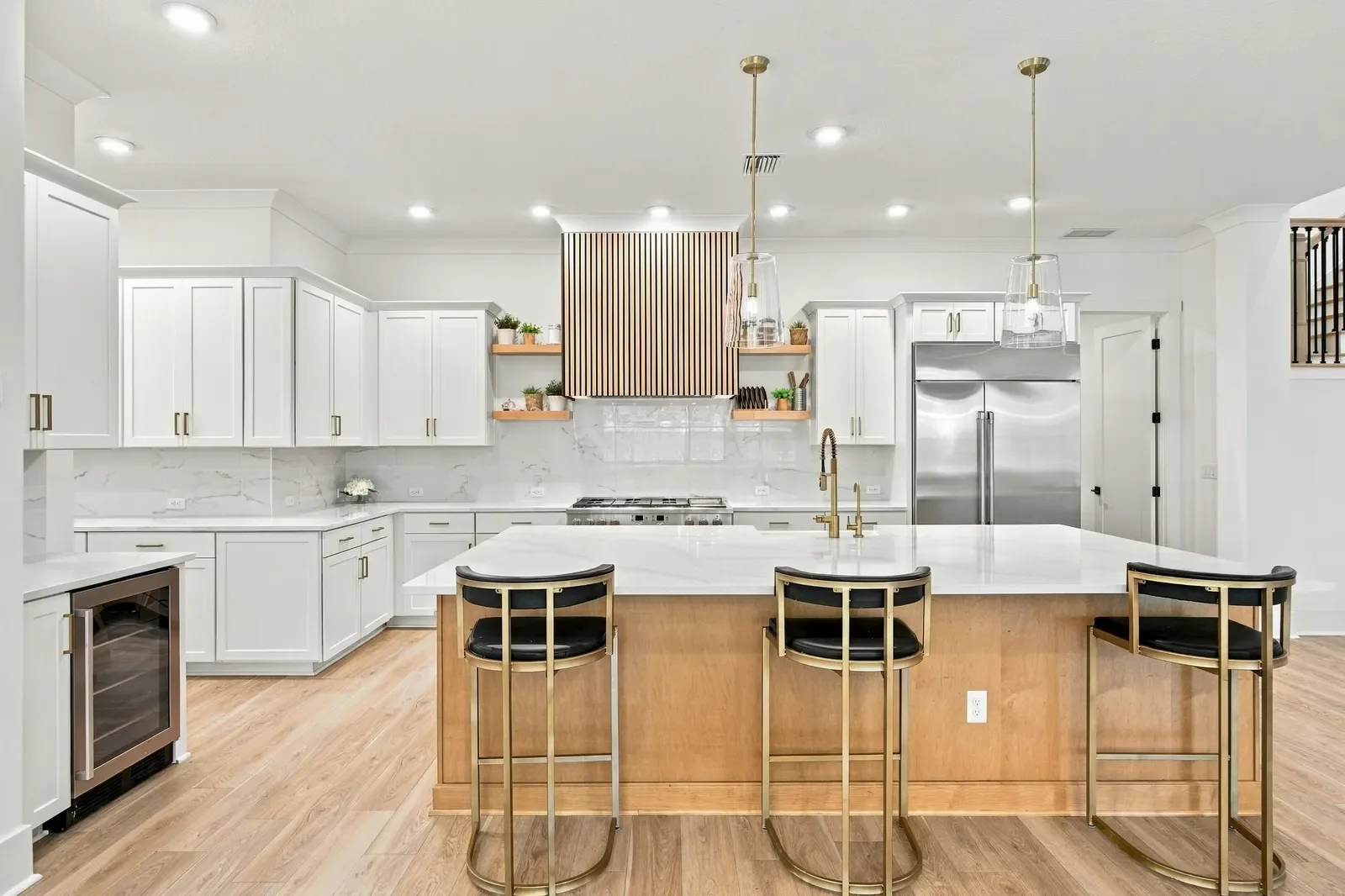 White and oak kitchen with waterfall island and brass pendants in Ponte Vedra Beach, FL. Real estate photography by Megapixeler