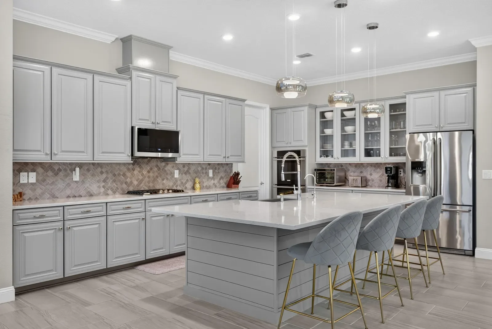 White kitchen with gold bar stools in St. Johns, FL. Real estate photography by Megapixeler